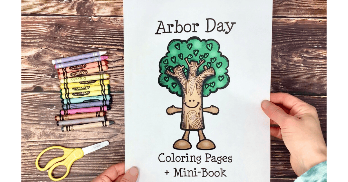 Woman holding example of Arbor Day coloring pages and mini-book cover with crayons and scissors.