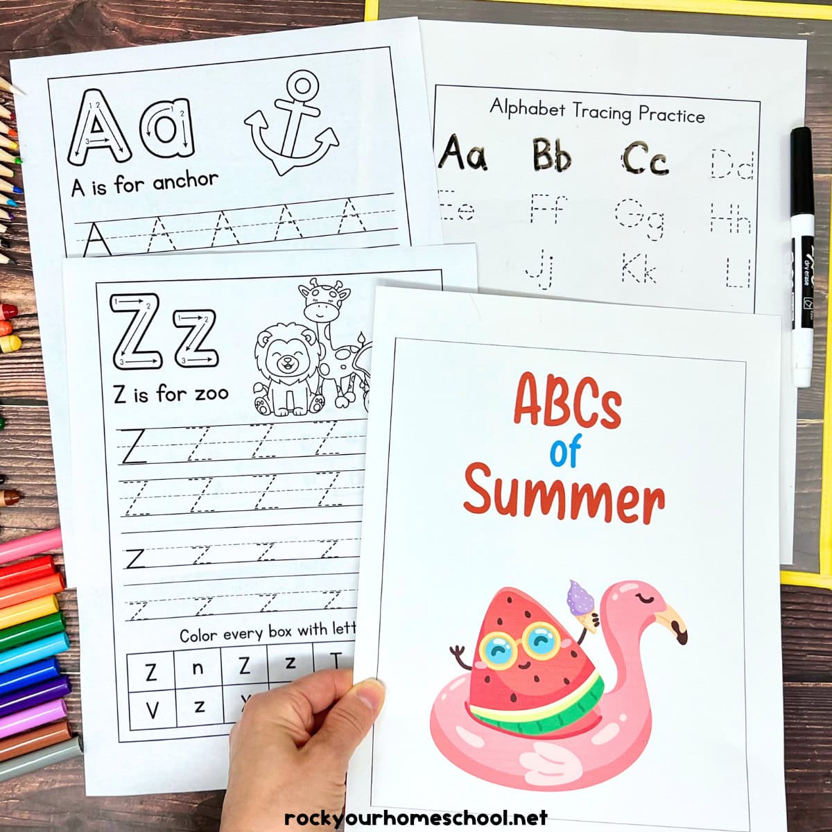Woman holding cover of ABCs of summer alphabet worksheets for print handwriting.