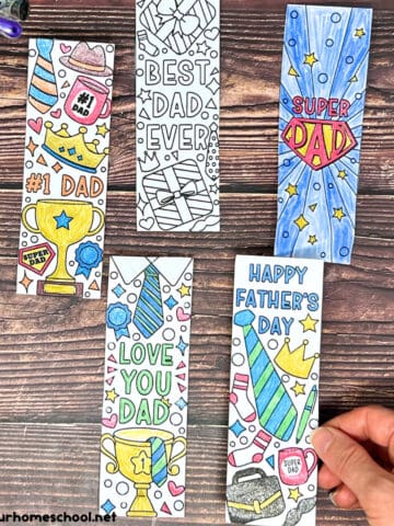 Woman holding Father's Day bookmarks to color with gel pens and scissors.