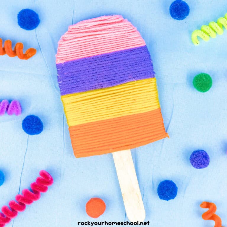 Example of yarn-wrapped popsicle craft for kids with pink, purple, yellow, and orange.