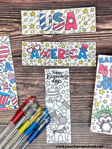 Woman holding example of free printable 4th of July coloring bookmarks with gel pens.