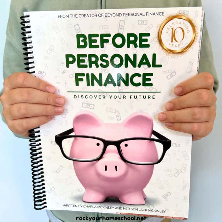 Boy holding Before Personal Finance workbook.