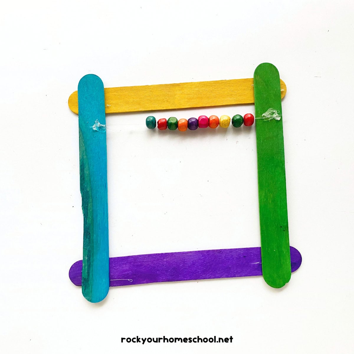 String of beads on square popsicle frame craft.