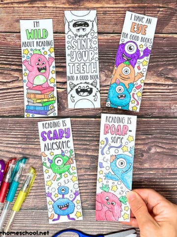 Woman holding examples of free printable monster bookmarks to color with gel pens.