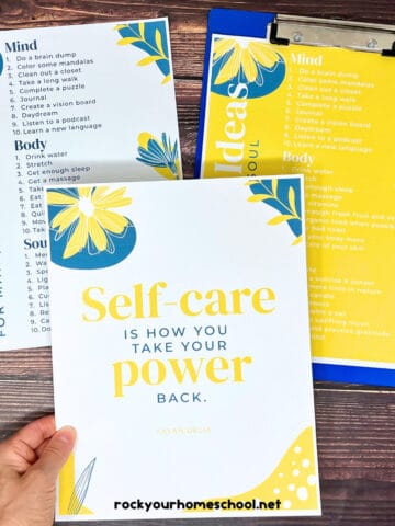 Woman holding self-care quote poster with checklists in background.