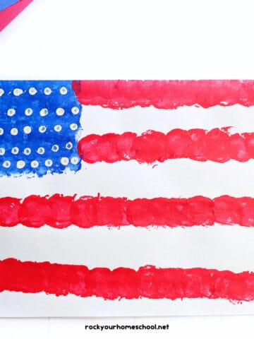 Example of easy American flag craft featuring a painting activity with red, white, and blue paint and uses cotton balls and Q-tips.