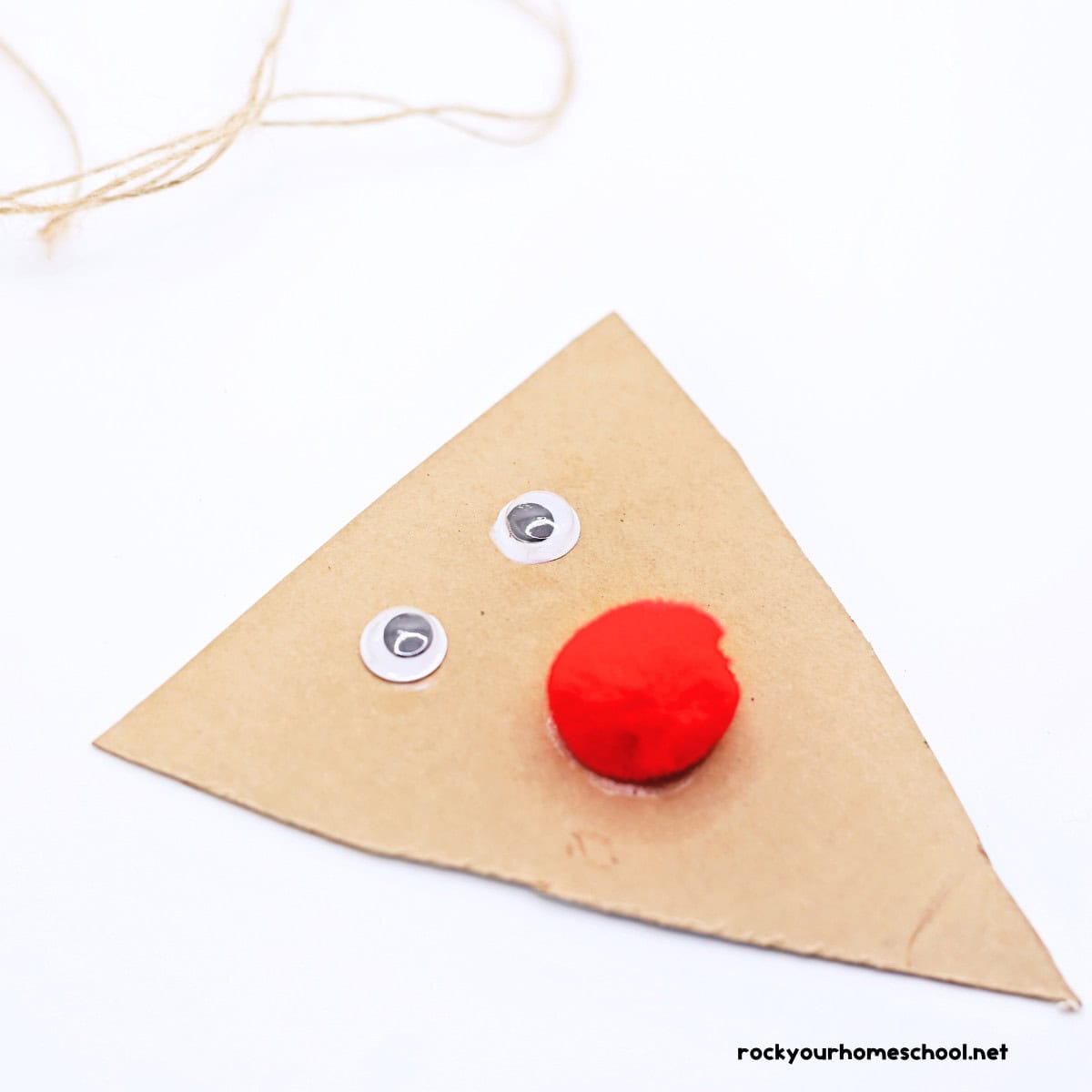 Cardboard triangle with 2 googly eyes and red pom pom.