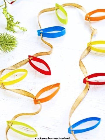 Example of colorful Christmas lights craft made out of toilet paper roll rings, paint, and ribbon.