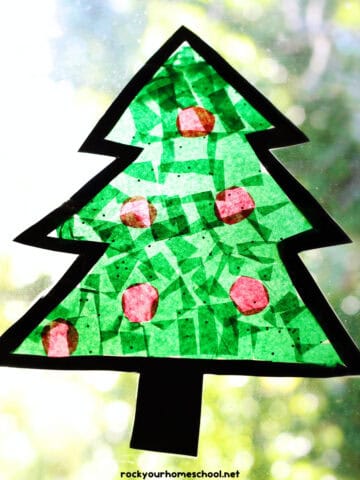 Example of easy Christmas suncatcher craft that's shaped like a tree on a window.