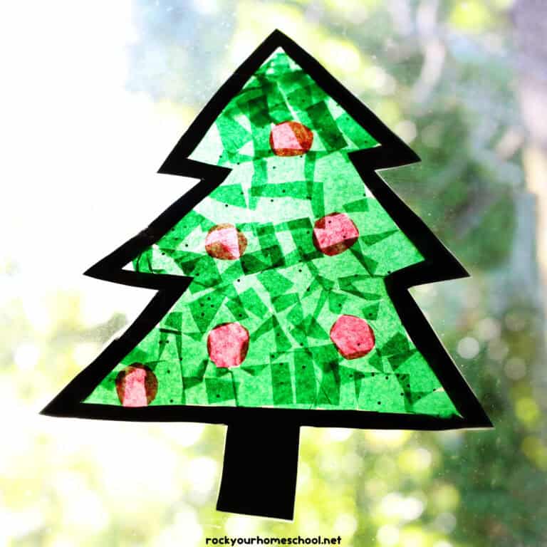 Example of easy Christmas suncatcher craft that's shaped like a tree on a window.