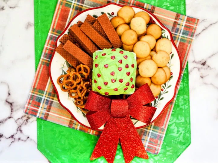 Plate of cookies and pretzels and red bow with Grinch dunkaroo dip recipe.