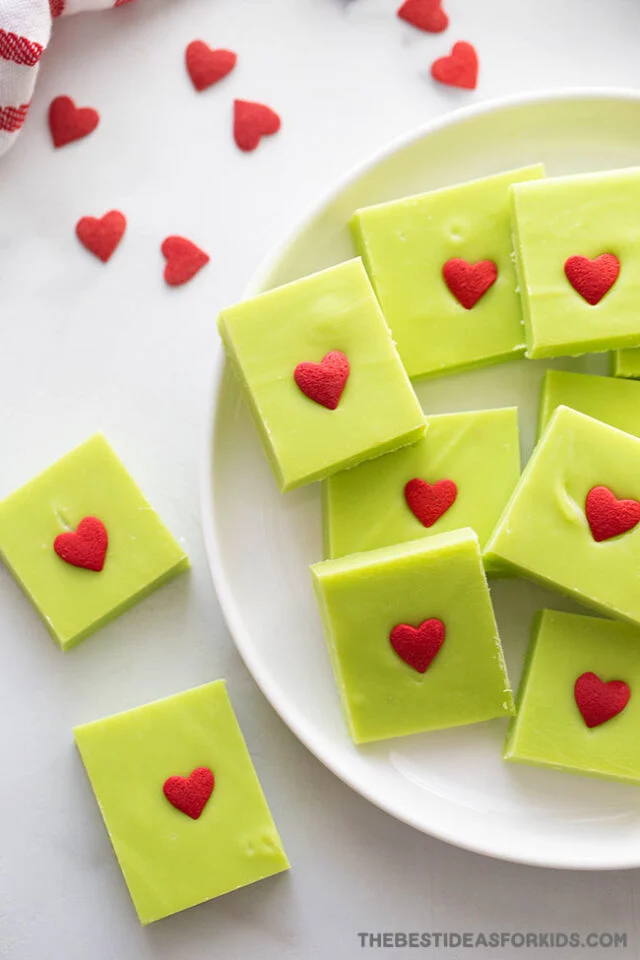 Plate of Grinch fudge with red candy hearts.