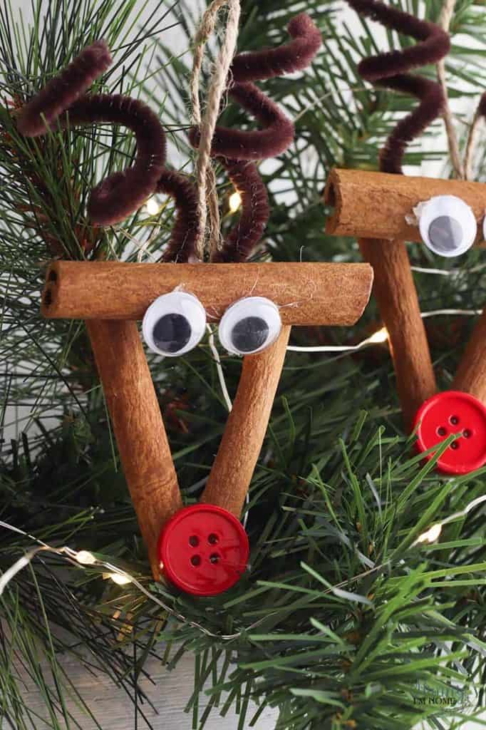 2 example of cute reindeer cinnamon stick ornaments with pipe cleaners, googly eyes, and buttons.