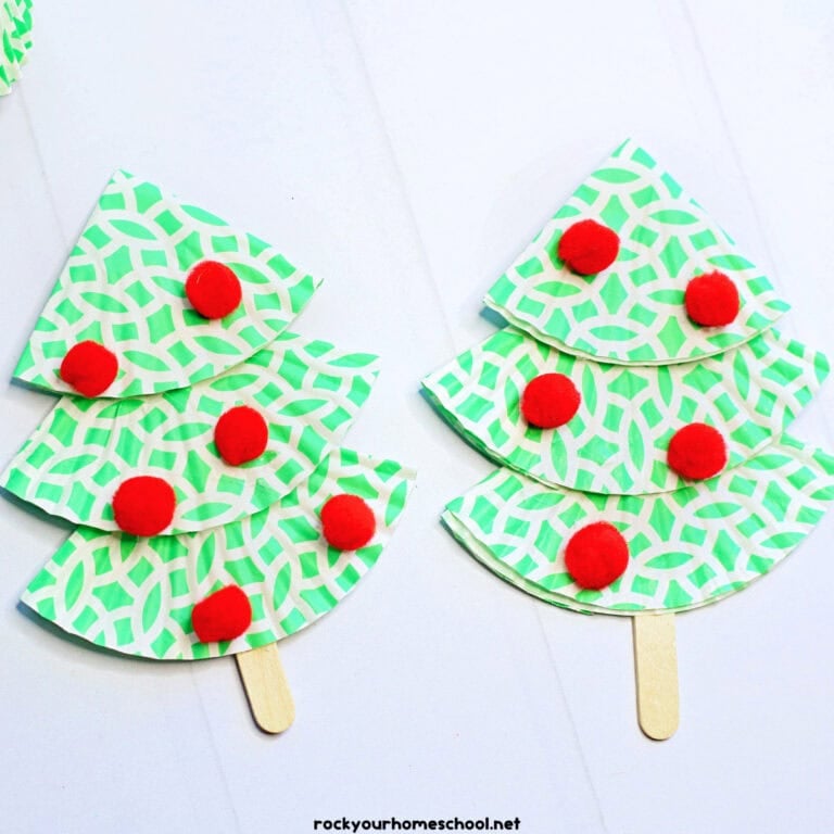 2 examples of cupcake liner Christmas tree crafts in green and white with popsicle stick and red pom poms.