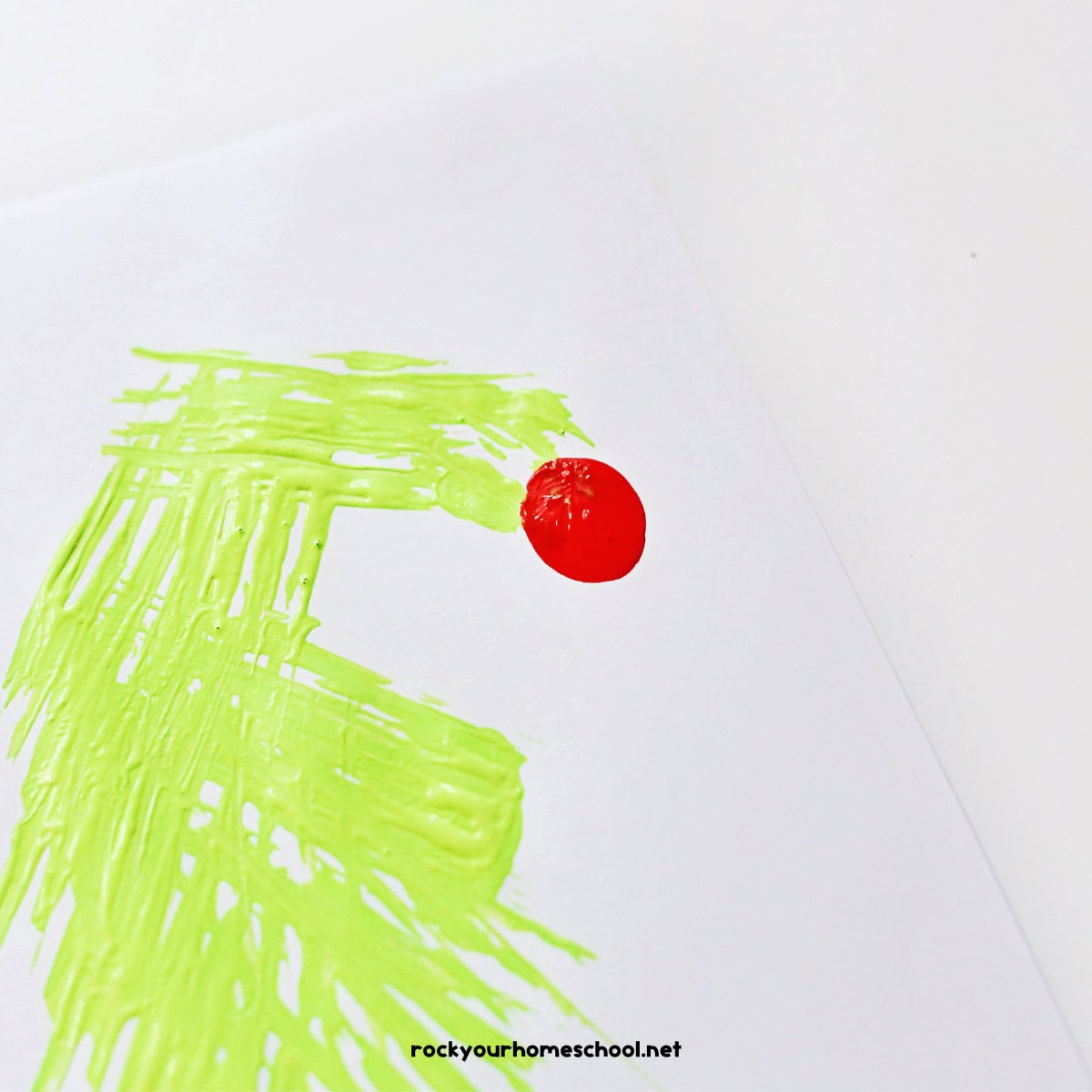 Green paint made with fork and red circle made with tumb print.