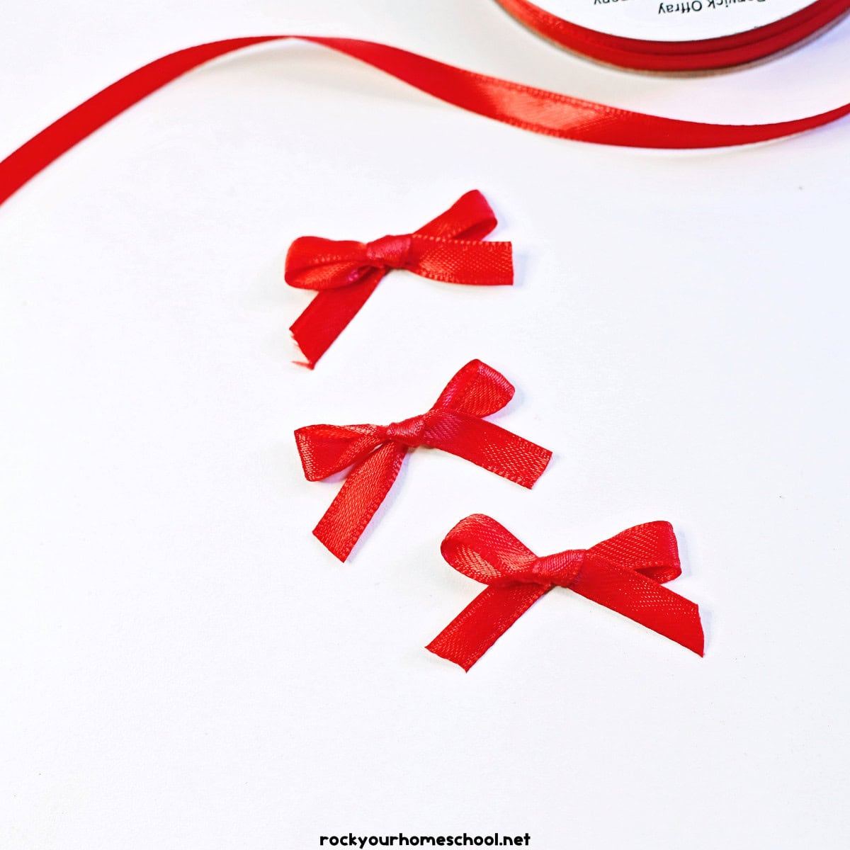 3 small red bows with ribbon.