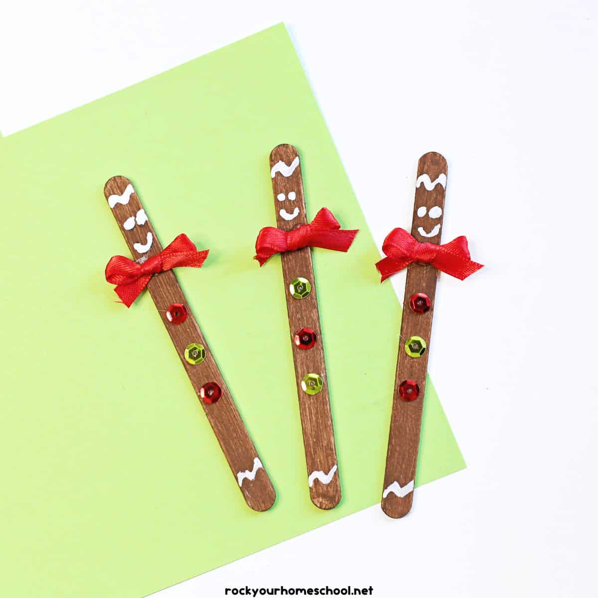 3 examples of easy gingerbread man crafts made with popsicle sticks, paint, ribbons, and sequins.