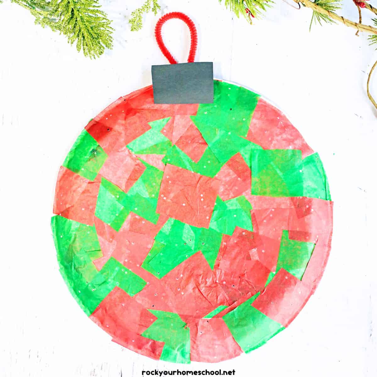 Example of easy paper plate ornament craft made with red and green tissue paper and pipe cleaner.