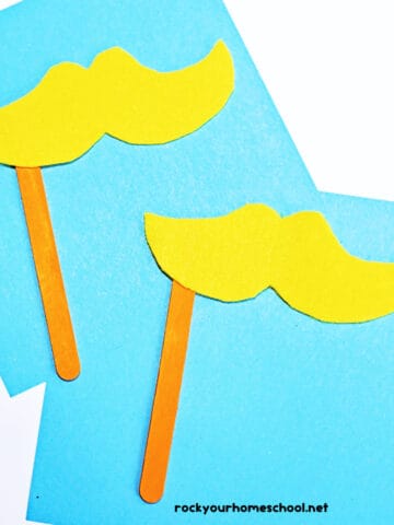 Two examples of The Lorax mustache craft on light blue paper.