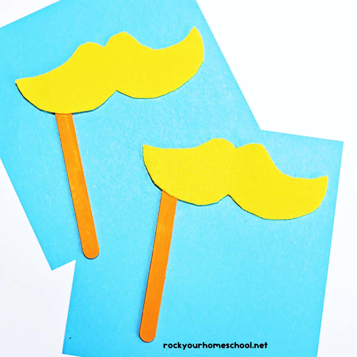 Two examples of The Lorax mustache craft on light blue paper.