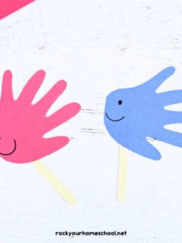 Examples of simple fish handprint craft in red and blue on popsicle sticks.