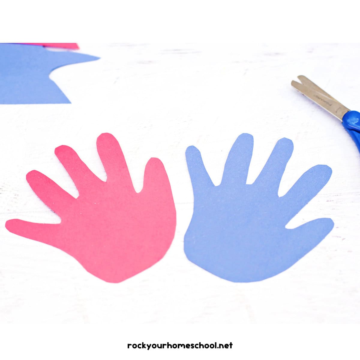 Red and blue construction paper hands with scissors.