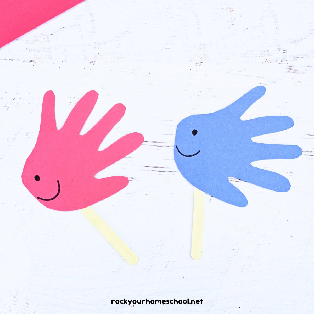 Examples of simple fish handprint craft in red and blue on popsicle sticks.