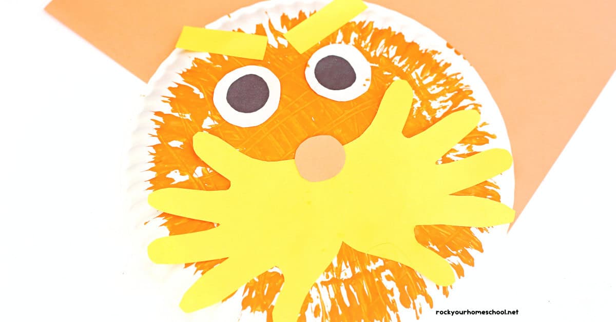 Example of Lorax paper plate craft made with orange paint and fork and yellow construction paper.