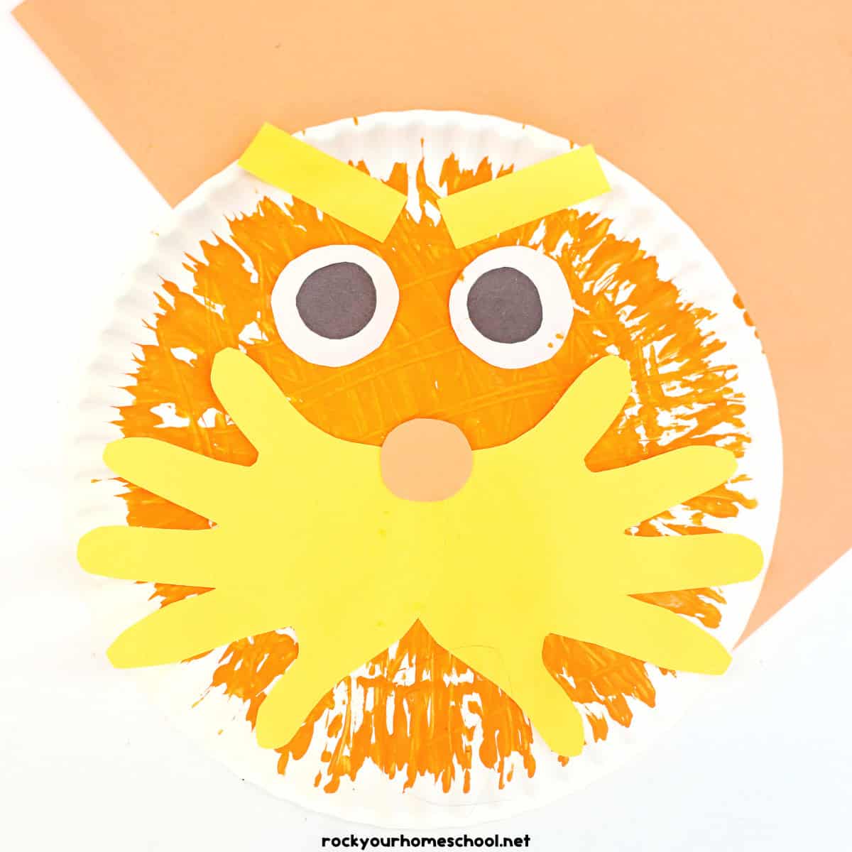 Example of The Lorax paper plate craft made with fork painting and paper handprints.