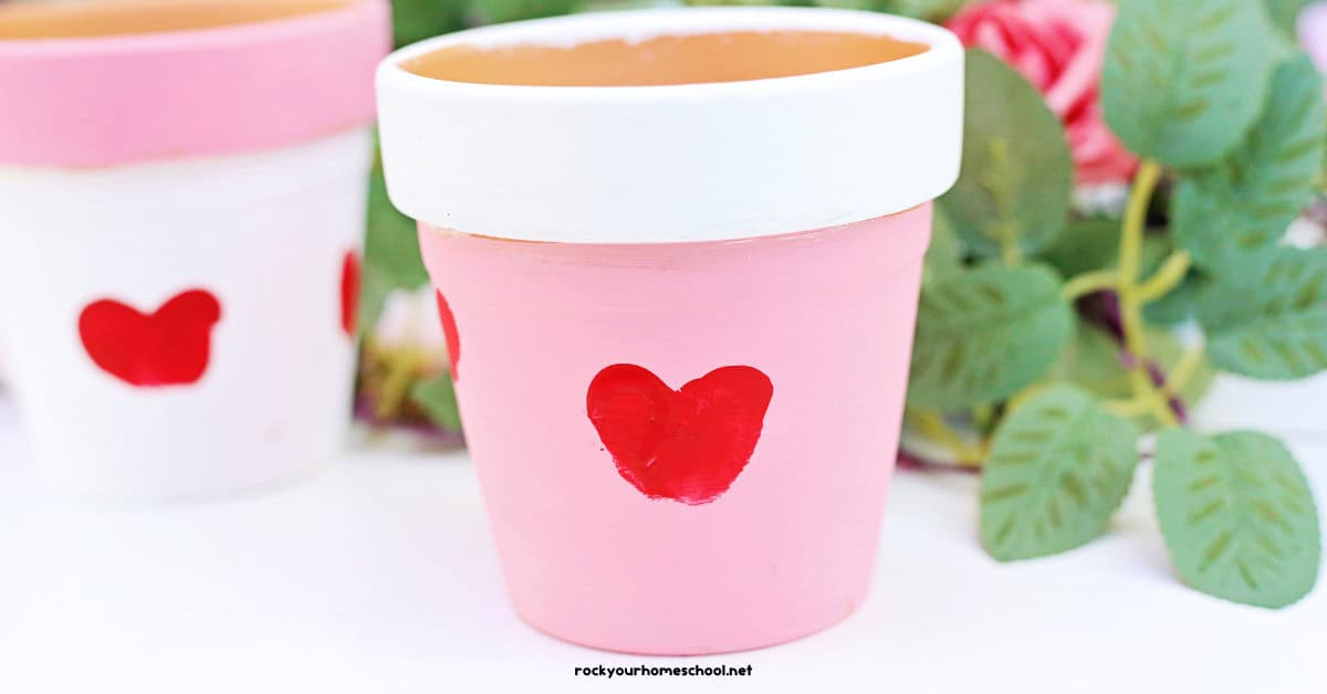 Two claypots painted white and pink with red thumbprint hearts.