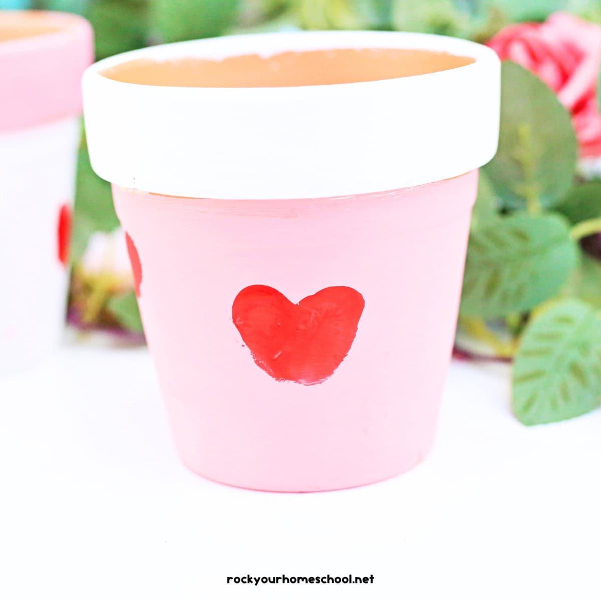 Claypot painted white and pink with red thumbprint heart.