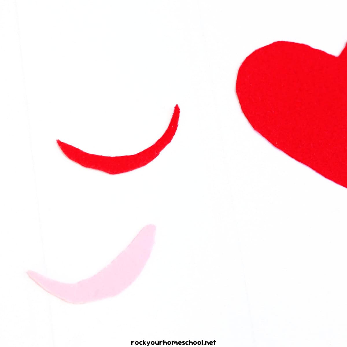 Red and pink felt pieces in shapes of smiles.