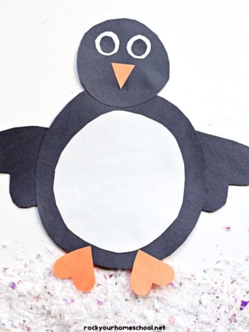 Example of easy penguin shape craft made with black, white, and orange construction paper.