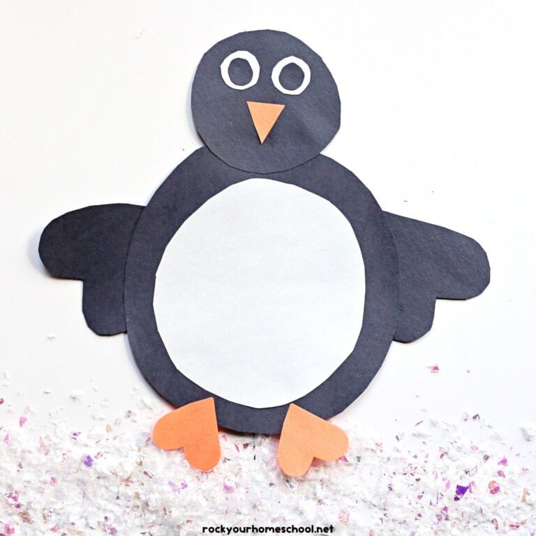 Example of easy penguin shape craft made with black, white, and orange construction paper.