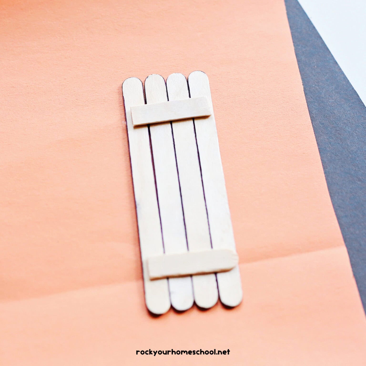 Four popsicle sticks glue together with pieces of popsicle stick holding the back.