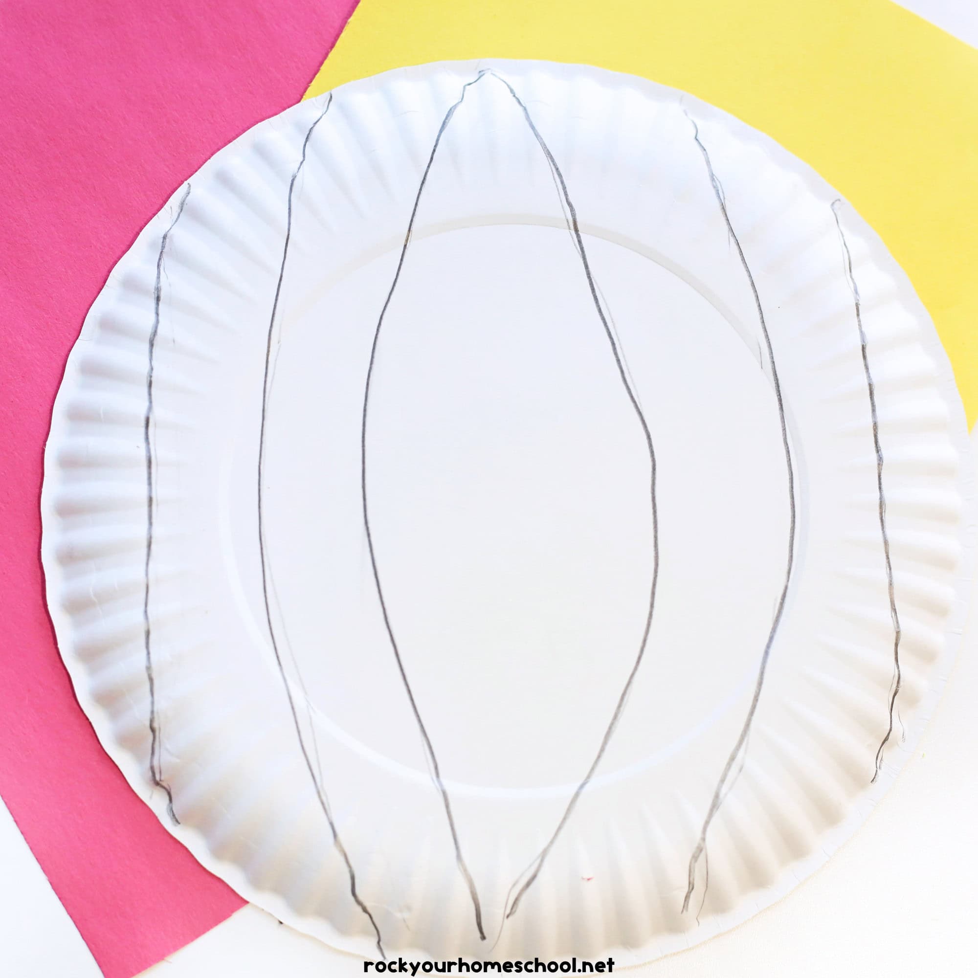 Paper plate with pencil drawn sections on red and yellow construction paper.