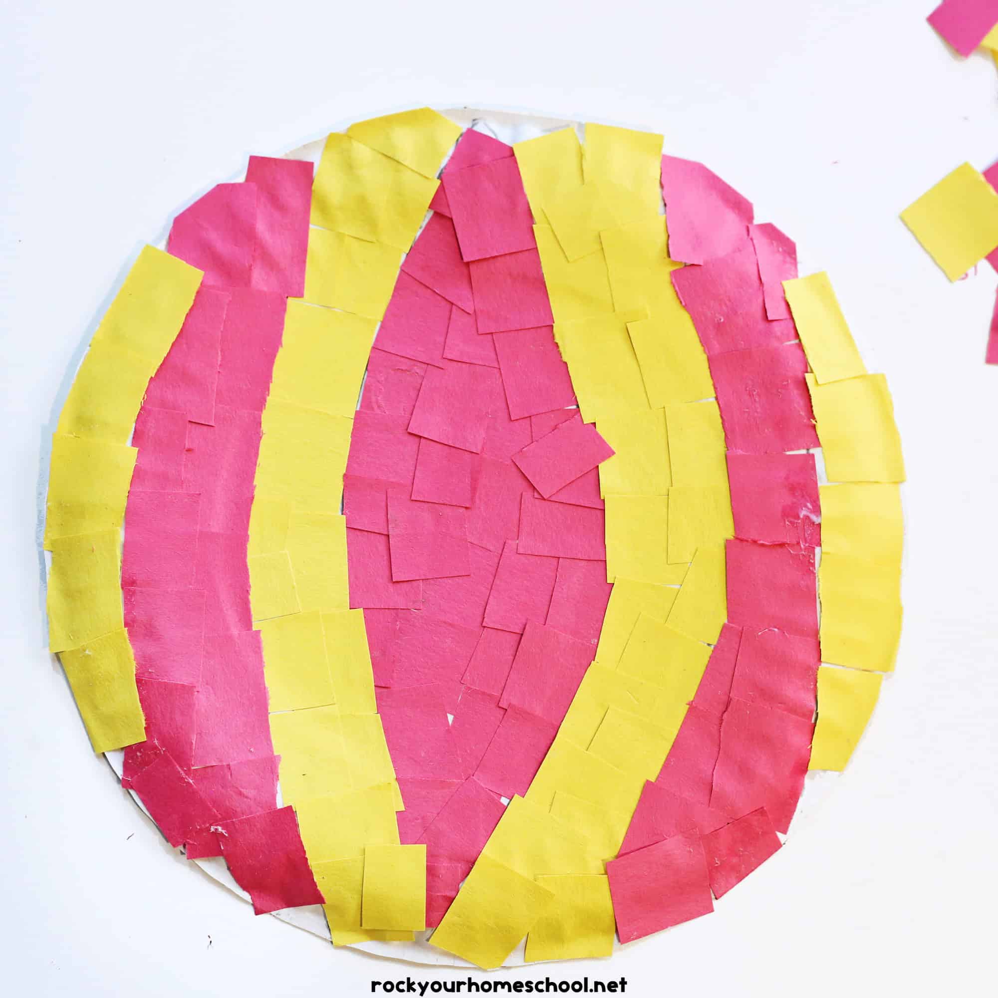 Paper plate with red and yellow torn paper.