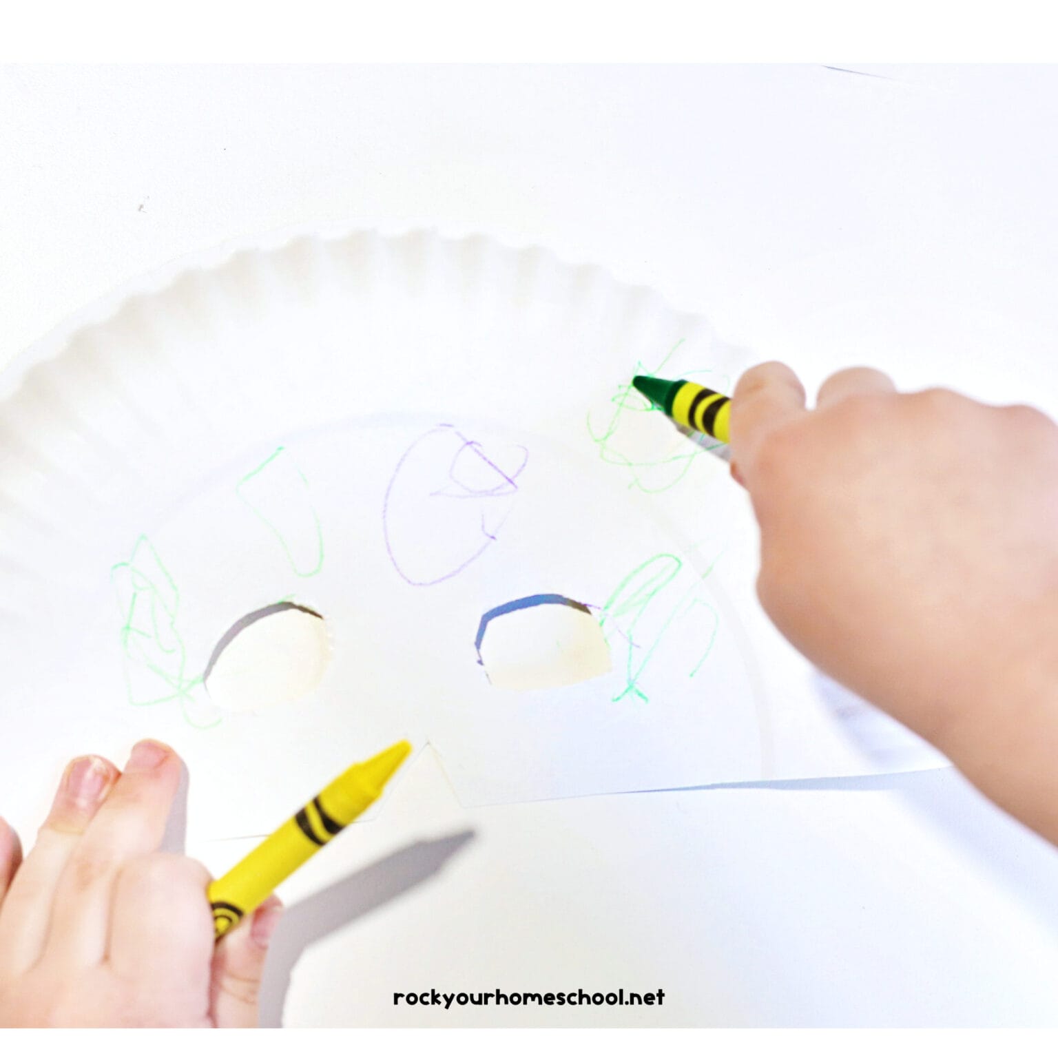 Child coloring paper plate mask.