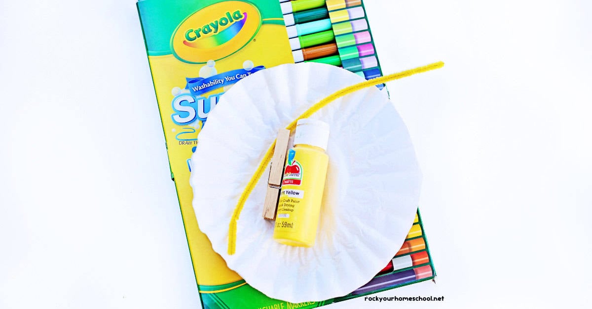 Washable markers, coffee filters, yellow pipe cleaner, clothespin, and yellow paint.