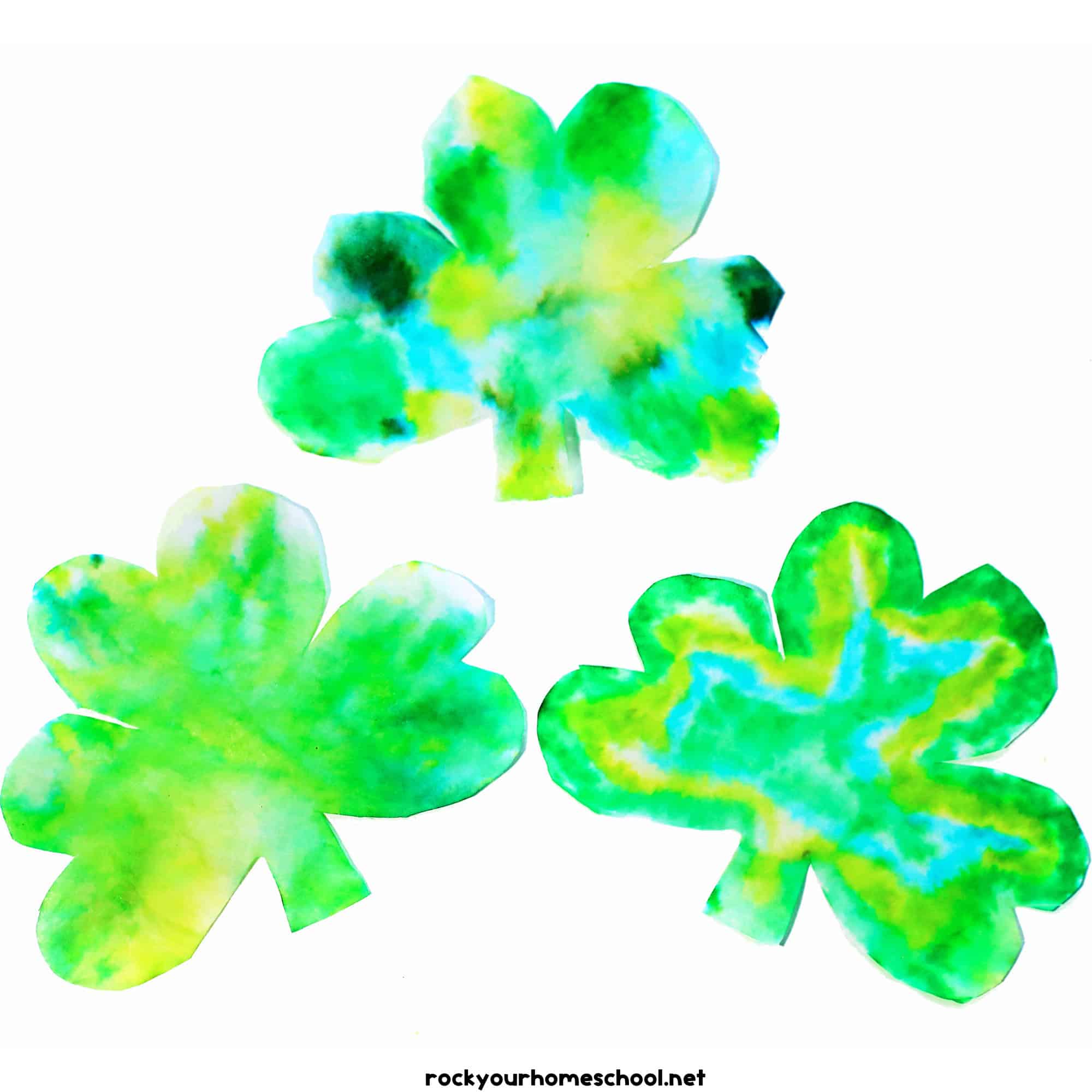 Three coffee filter shamrock crafts with different shades of green.