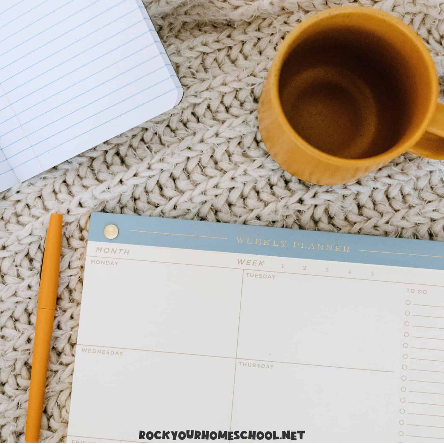 Yellow mug, calendar, and pencil for ways to feature your homeschool routine.