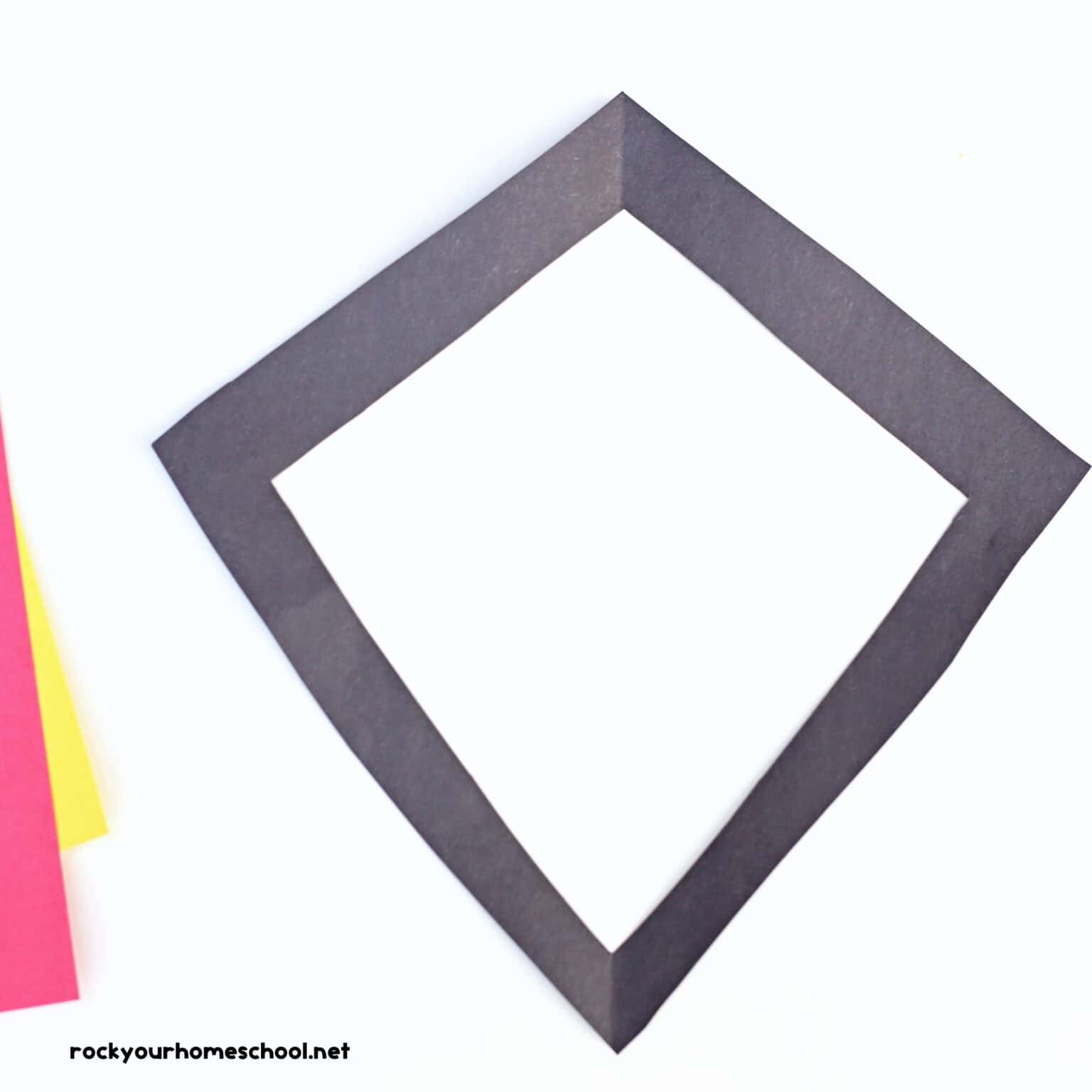 Black paper cut into diamond shape frame.