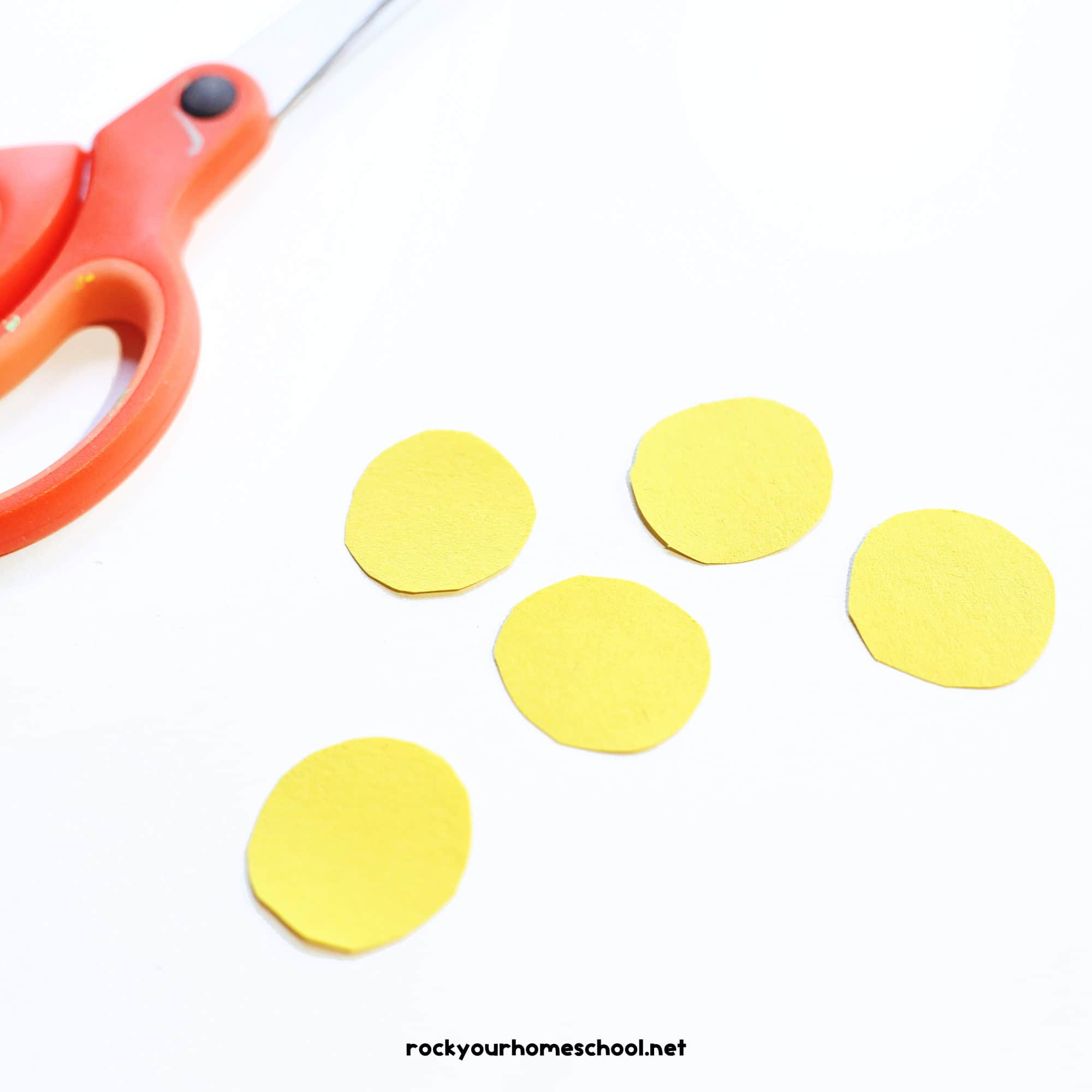 Five yellow paper circles with scissors.