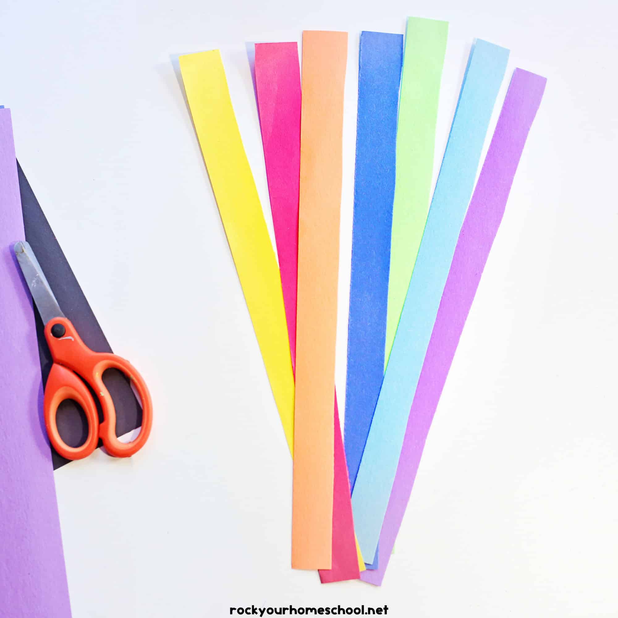 Scissors with rainbow of paper strips.