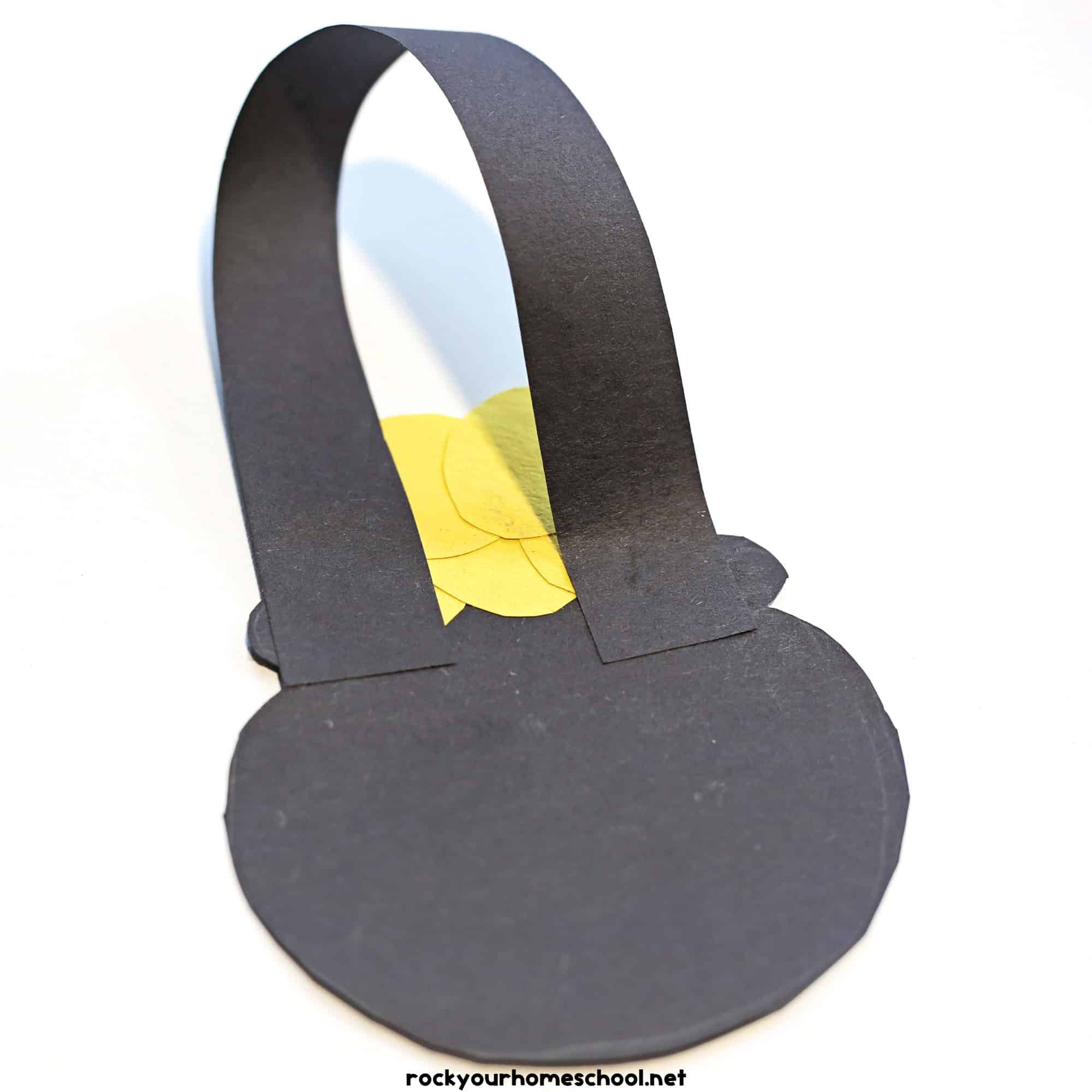 Black paper pot with paper strip handle.