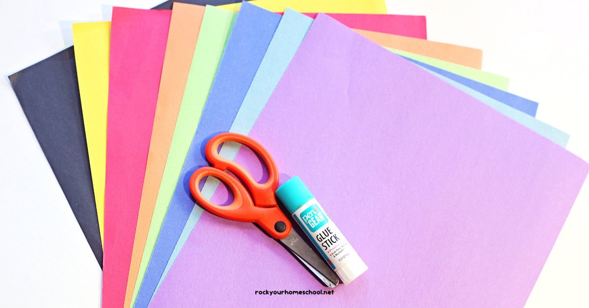 Rainbow of construction paper with scissors and glue.