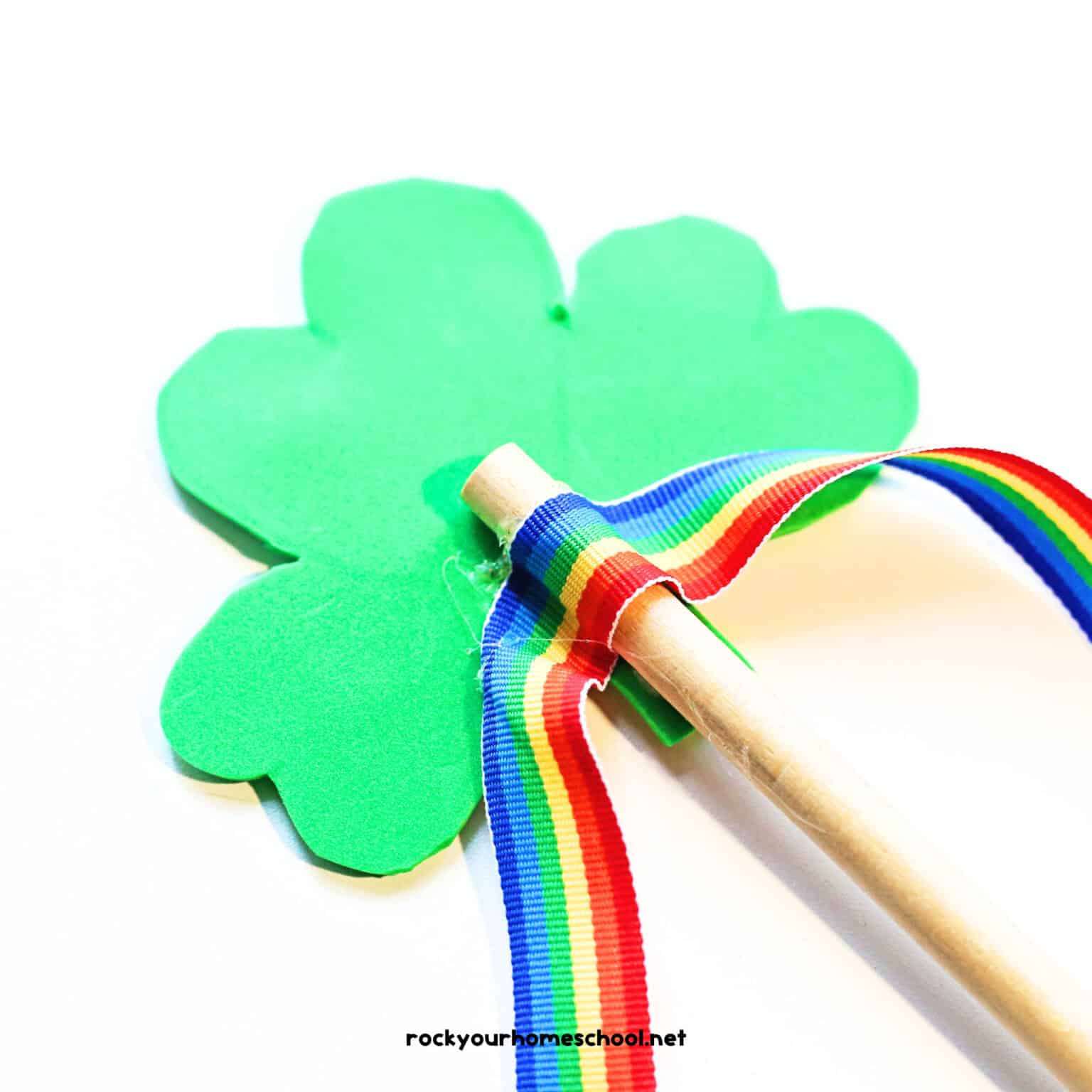 Rainbow ribbon glued to back of wood dowel rod on green shamrock.
