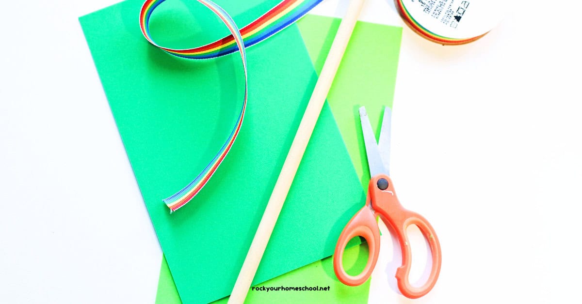 Green foam sheets, rainbow ribbon, wood dowel, and scissors.