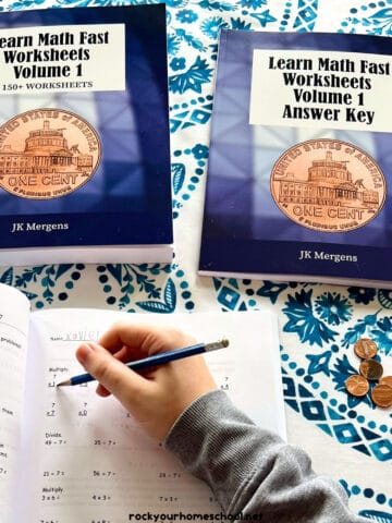 Boy using pencil to work on Volume 1 of Learn Math Fast with worksheets and answer key.