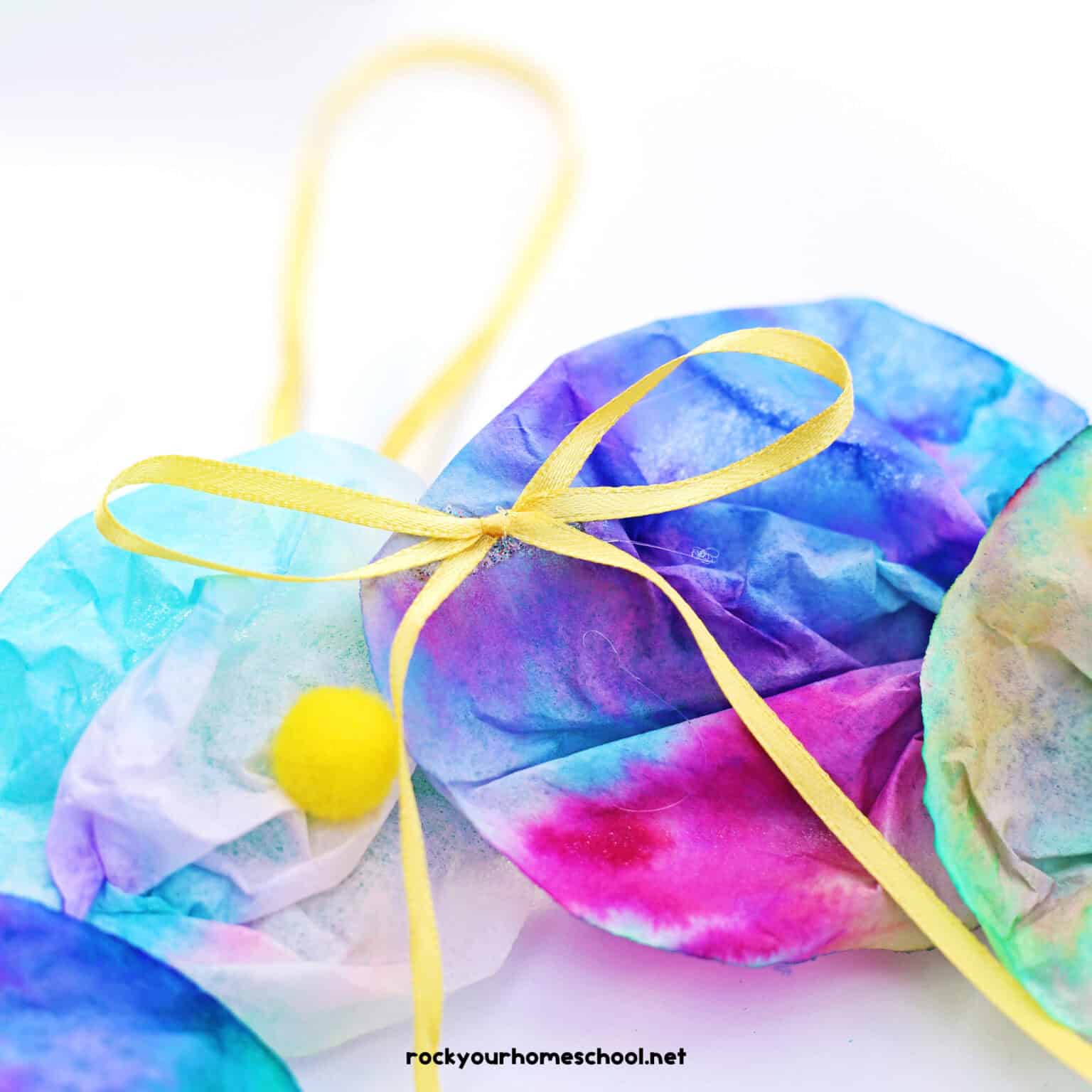 Yellow ribbon bow on coffee filter flower wreath.